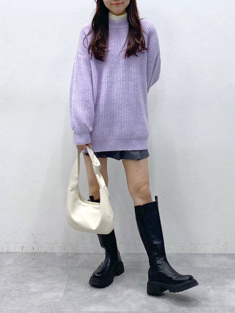 ブラック系のブーツ、パープル系のニット/セーター、ベージュ系のTシャツ/カットソーを着用したレディースの冬コーディネートの3枚目の写真