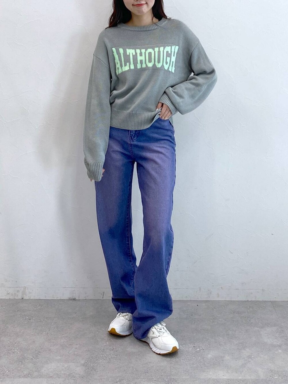 パープル系のデニムパンツ、グレー系のニット/セーターを着用したレディースの冬コーディネートの2枚目の写真