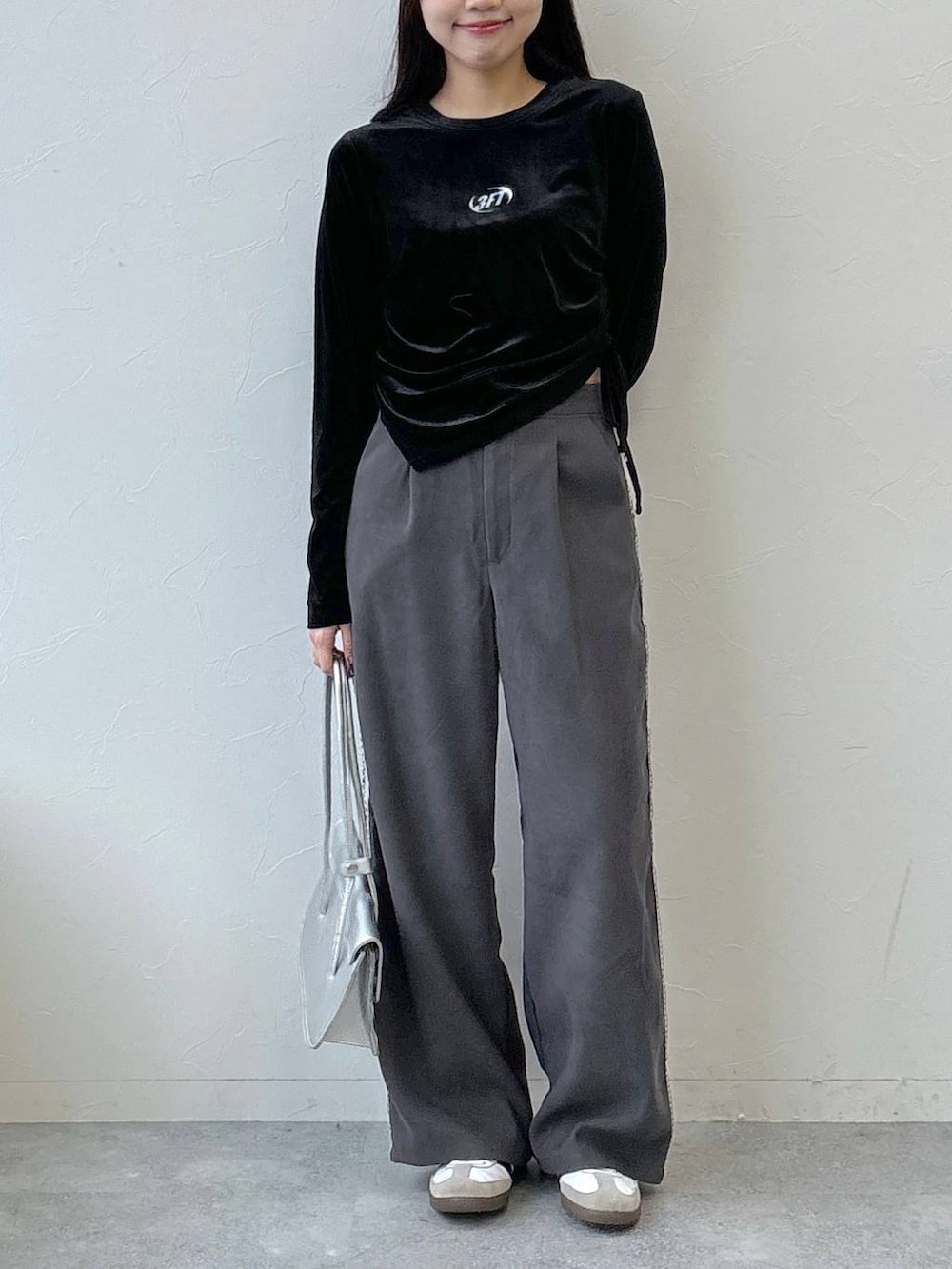 シルバー系のショルダーバッグ、グレー系のスラックス、ブラック系のTシャツ/カットソーを着用したレディースの冬コーディネートの2枚目の写真