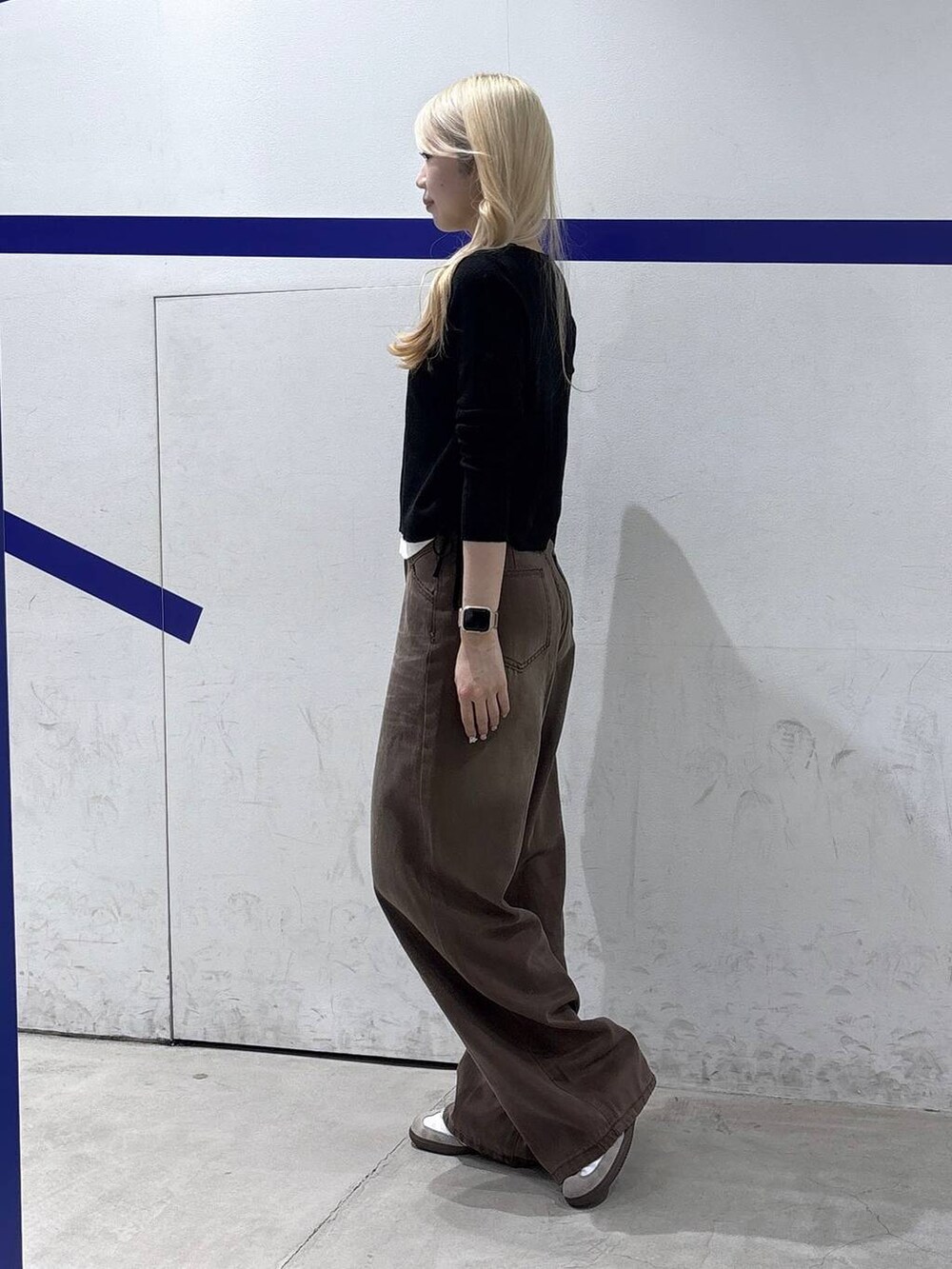 ブラウン系のデニムパンツ、ブラック系のTシャツ/カットソーを着用したレディースの秋コーディネートの3枚目の写真