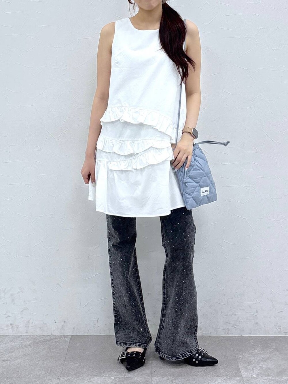 ブラック系のサンダル、ホワイト系のワンピース、ブラック系のデニムパンツを着用したレディースの夏コーディネートの2枚目の写真