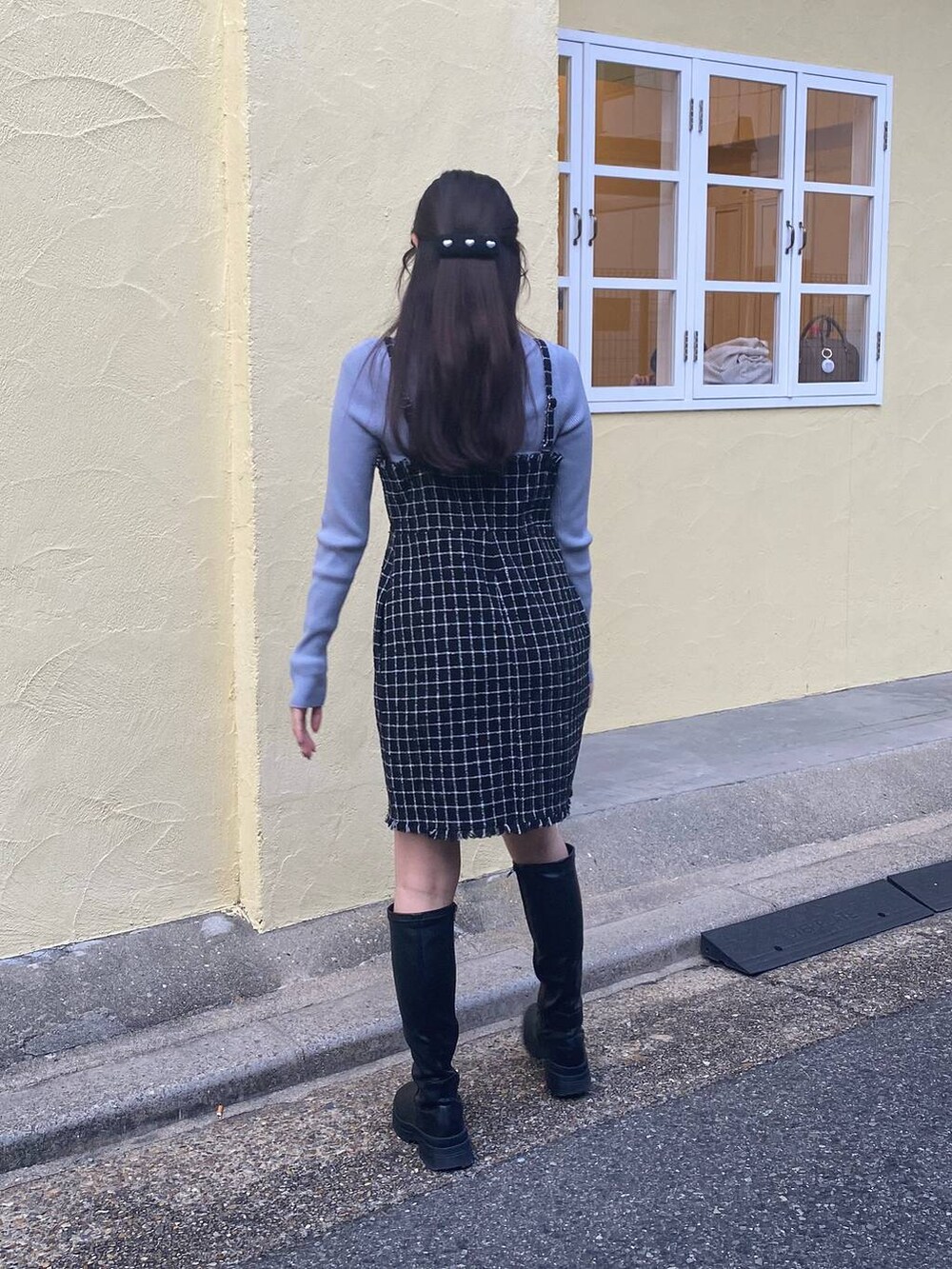 ブラック系のショルダーバッグ、ブルー系のニット/セーター、ブラック系のワンピースを着用したレディースの冬コーディネートの6枚目の写真