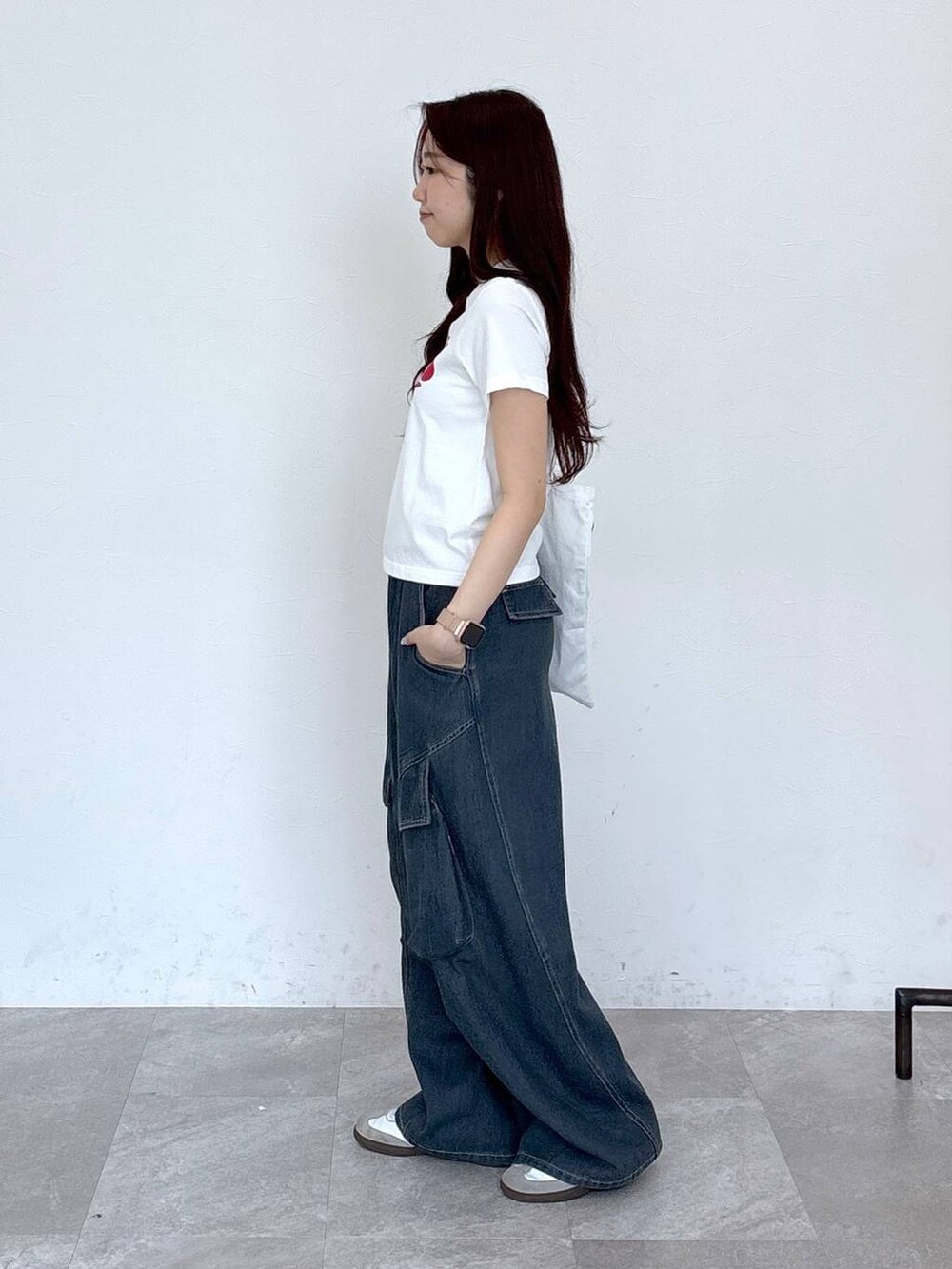 ブルー系のカーゴパンツ、その他のトートバッグ、ホワイト系のTシャツ/カットソーを着用したレディースの春コーディネートの4枚目の写真