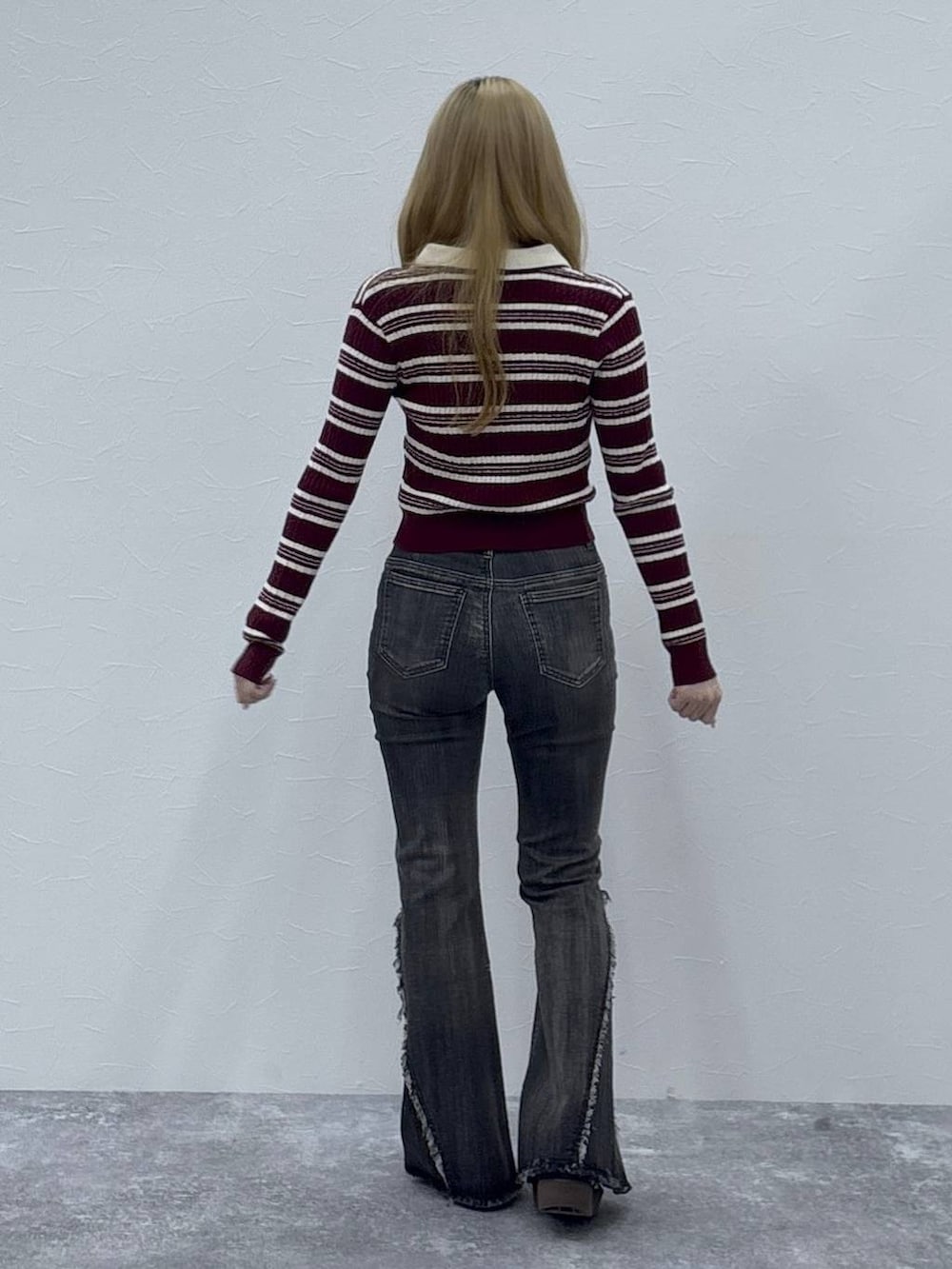 レッド系のニット/セーター、ブラック系のデニムパンツを着用したレディースの秋コーディネートの4枚目の写真