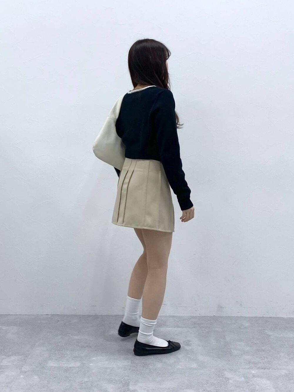 ベージュ系のスカート、ブラック系のカーディガン/ボレロを着用したレディースの春コーディネートの4枚目の写真