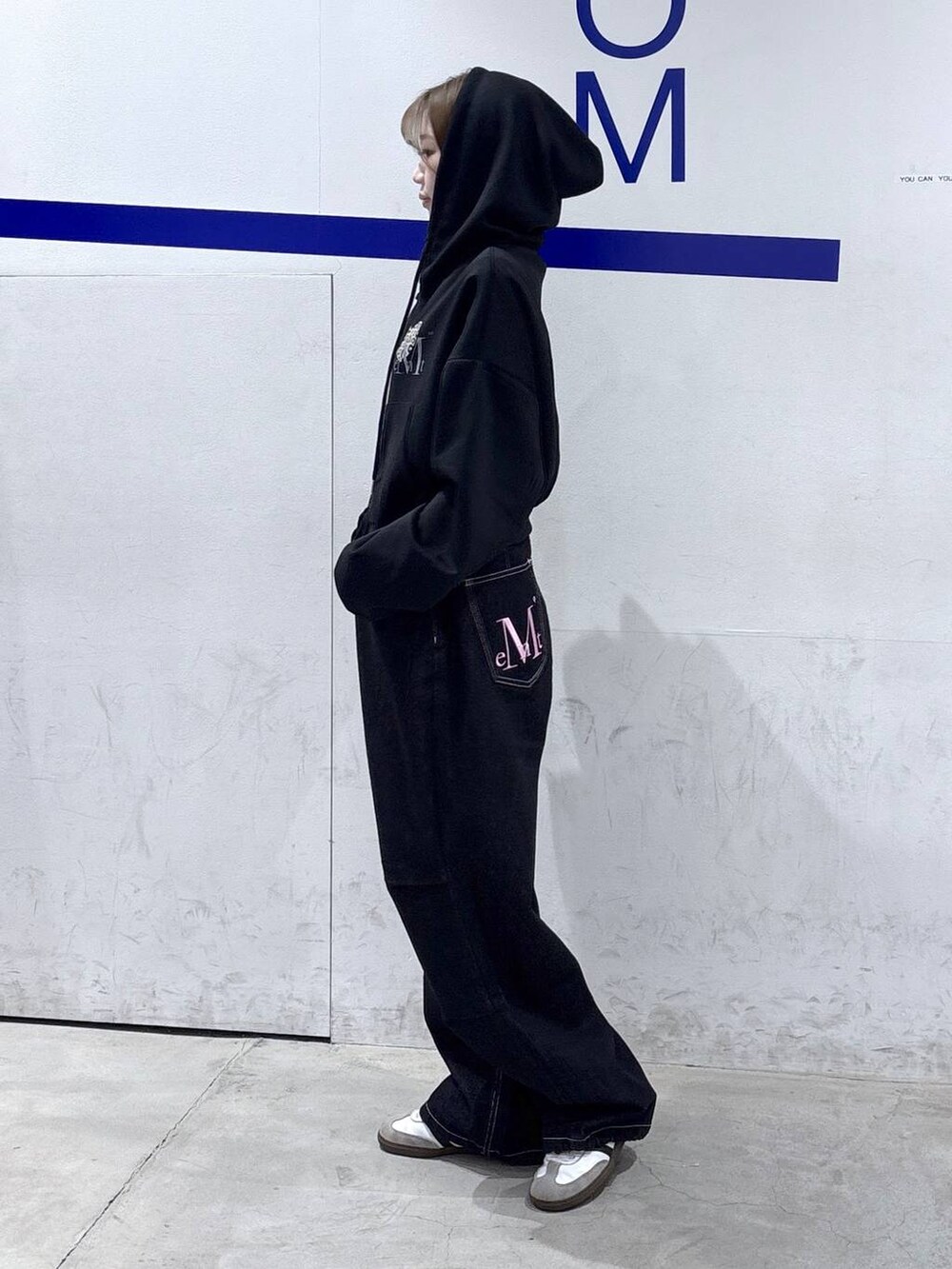 ブラック系のパーカー、ブラック系のデニムパンツを着用したレディースの春コーディネートの3枚目の写真