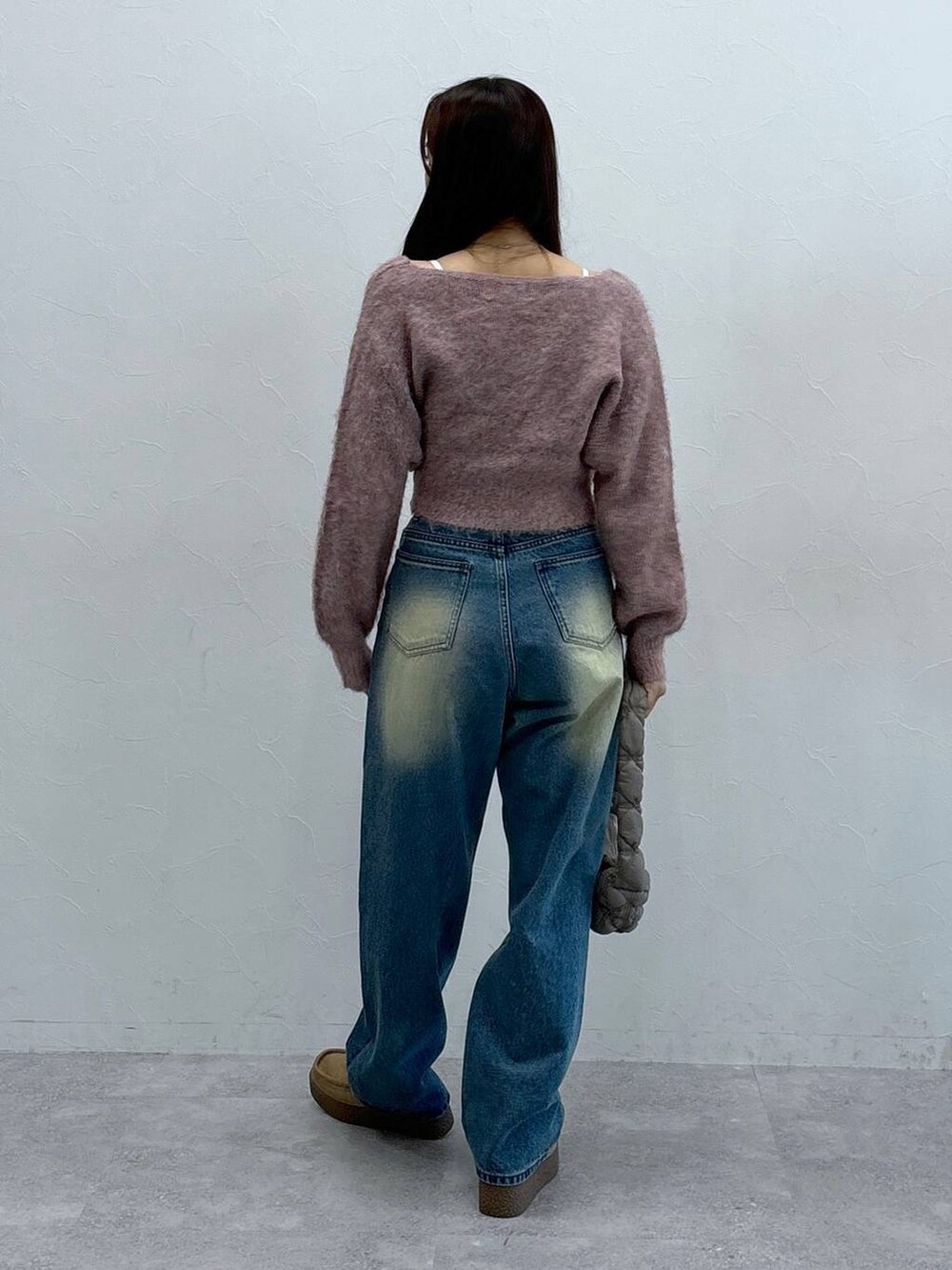 グレー系のショルダーバッグ、オレンジ系のカーディガン/ボレロ、ブルー系のデニムパンツを着用したレディースの秋コーディネートの4枚目の写真