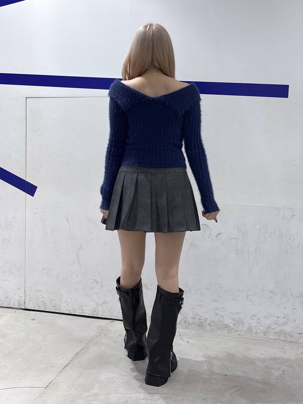 ブラック系のブーツ、ブルー系のニット/セーター、グレー系のスカートを着用したレディースの秋コーディネートの4枚目の写真
