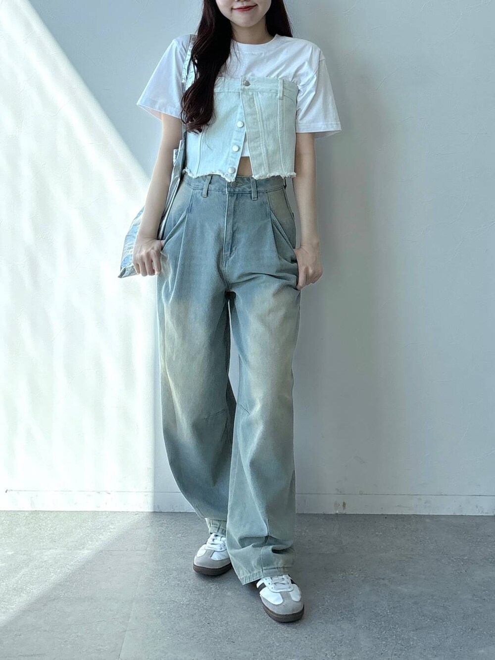 ブルー系のデニムパンツ、ホワイト系のTシャツ/カットソー、ブルー系のベストを着用したレディースの春コーディネートの2枚目の写真