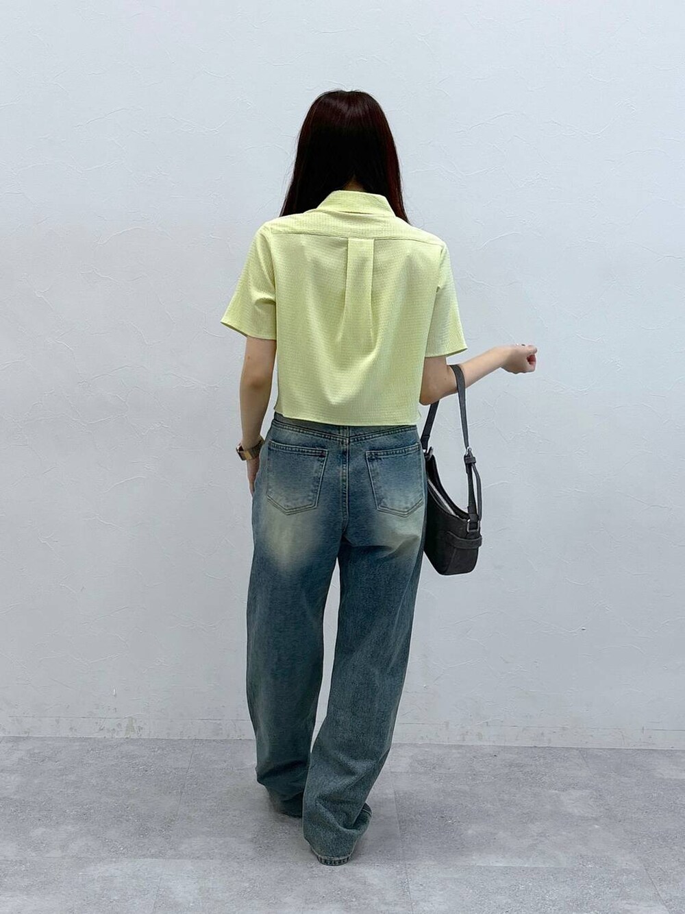 ブルー系のデニムパンツ、ブラック系のトートバッグ、グリーン系のシャツ/ブラウスを着用したレディースの夏コーディネートの4枚目の写真