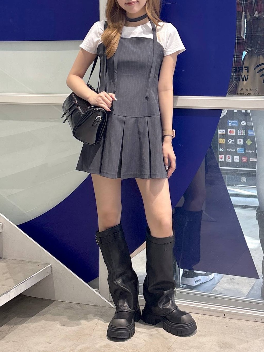 ホワイト系のTシャツ/カットソー、ブラック系のハンドバッグ、ブラック系のブーツを着用したレディースの夏コーディネートの2枚目の写真