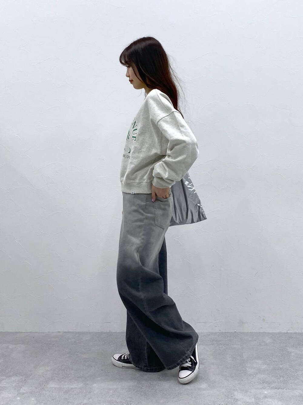 グレー系のトートバッグ、ブラック系のデニムパンツを着用したレディースの春コーディネートの3枚目の写真