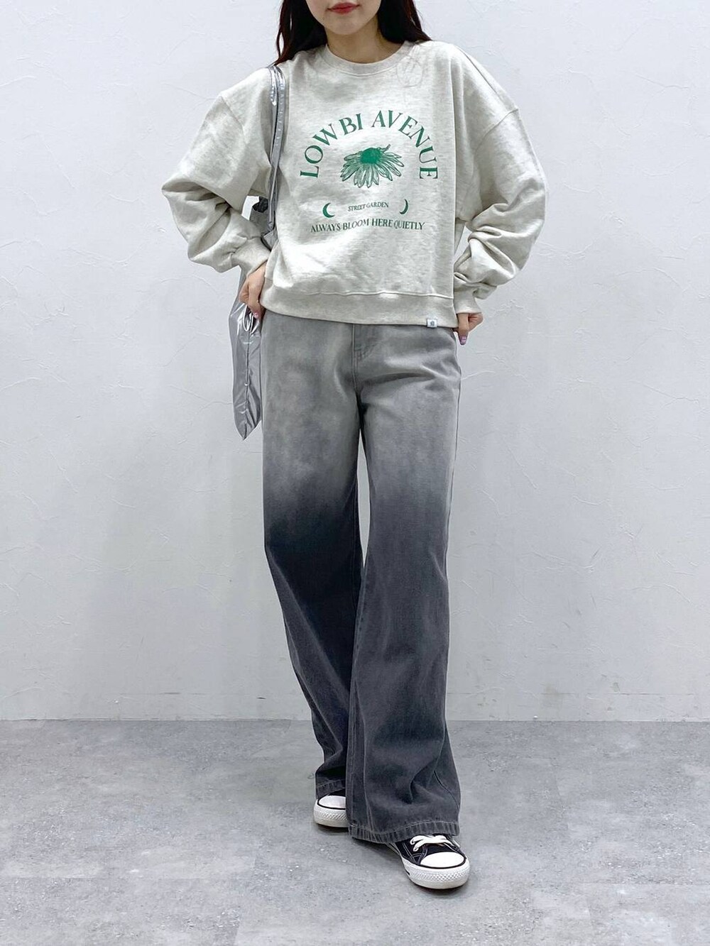 グレー系のトートバッグ、ブラック系のデニムパンツを着用したレディースの春コーディネートの2枚目の写真