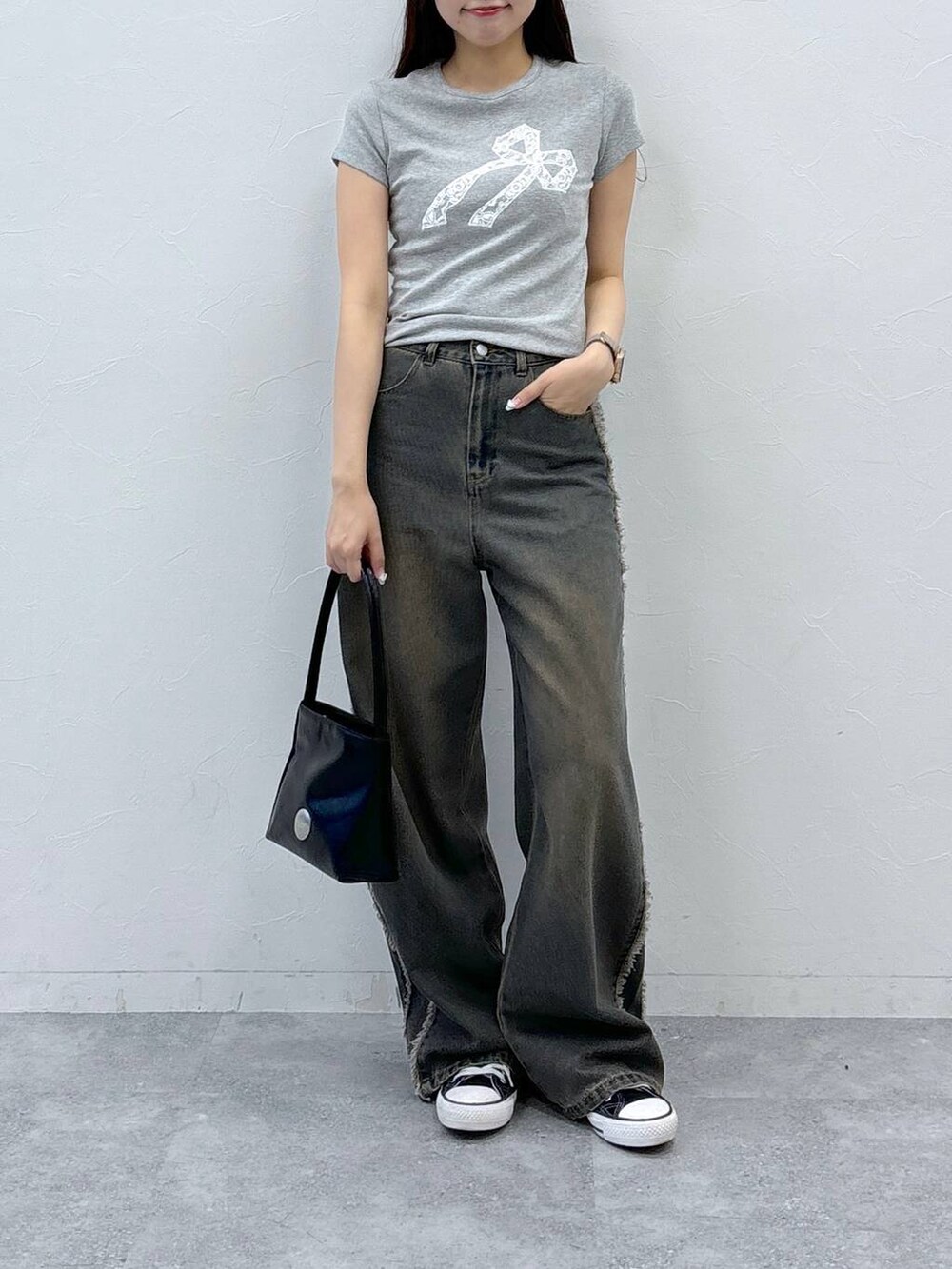 ブルー系のデニムパンツ、グレー系のTシャツ/カットソー、ブラック系のハンドバッグを着用したレディースの夏コーディネートの2枚目の写真