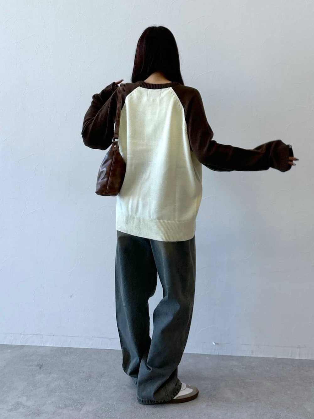 ブラウン系のニット/セーター、ブルー系のデニムパンツ、ブラウン系のハンドバッグを着用したレディースの冬コーディネートの6枚目の写真