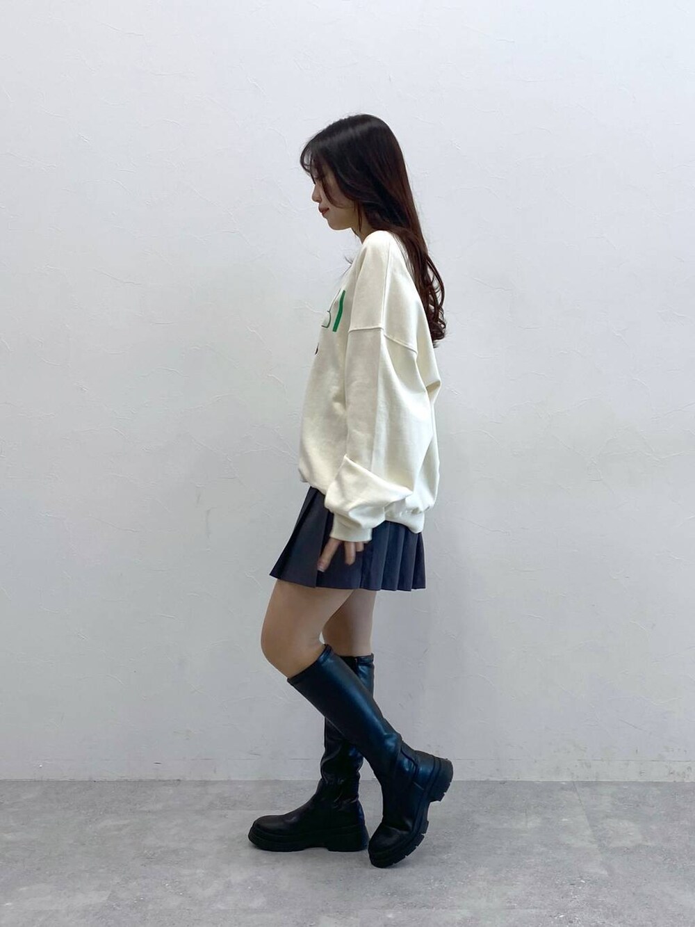 ホワイト系のスウェット、ブルー系のショルダーバッグ、グレー系のスカートを着用したレディースの冬コーディネートの4枚目の写真