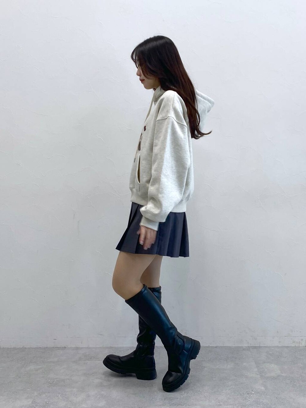 グレー系のスカート、ベージュ系のパーカーを着用したレディースの冬コーディネートの3枚目の写真