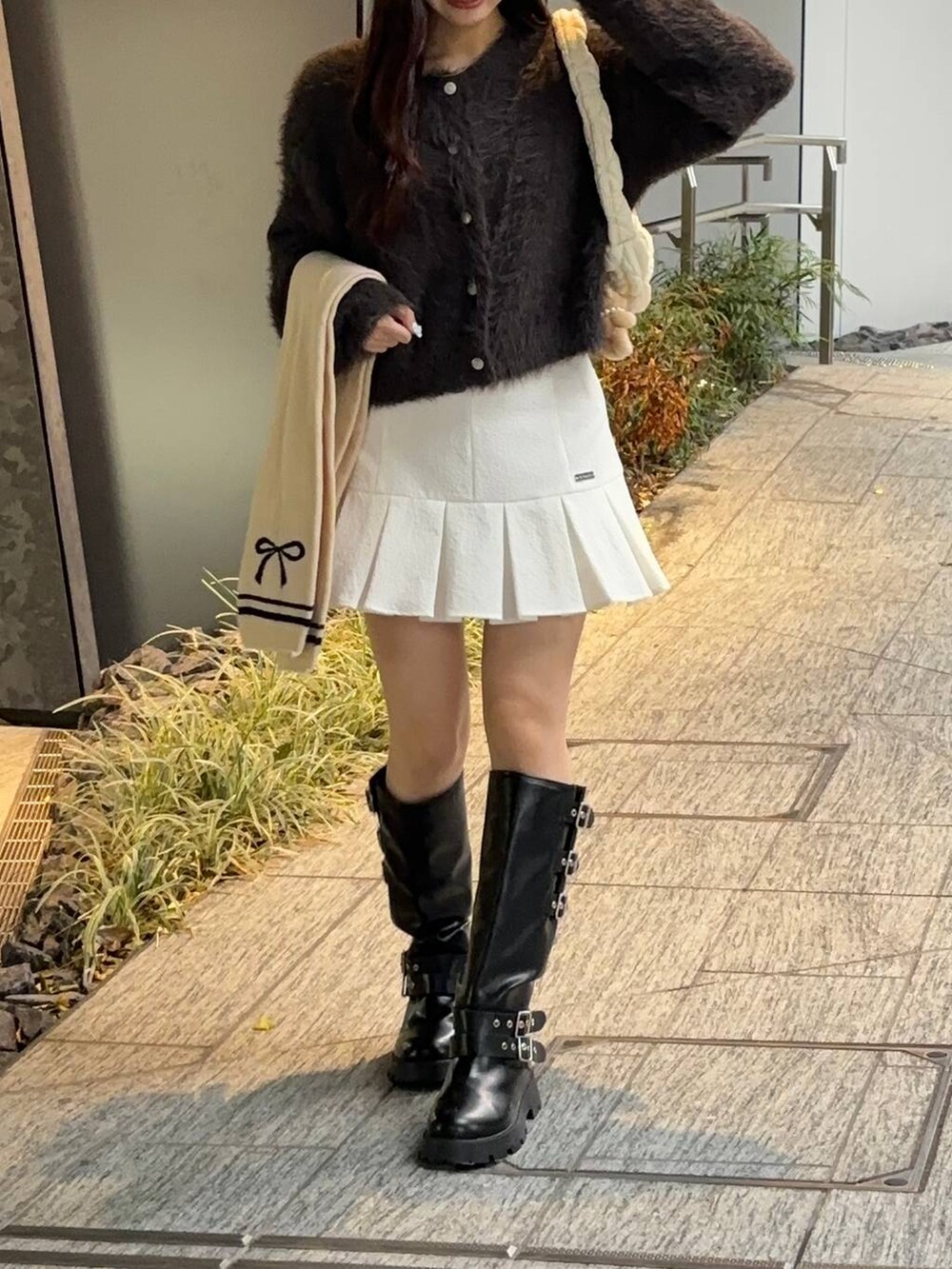 ホワイト系のショルダーバッグ、グレー系のカーディガン/ボレロ、ホワイト系のスカートを着用したレディースの秋コーディネートの2枚目の写真