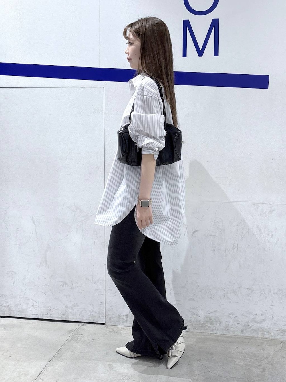 ブラック系のデニムパンツ、ホワイト系のパンプス、ホワイト系のシャツ/ブラウスを着用したレディースの春コーディネートの3枚目の写真