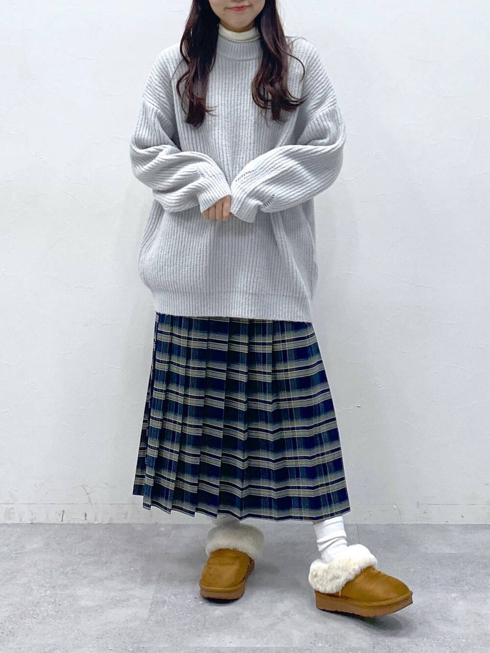 ブラック系のブーツ、グレー系のニット/セーター、ベージュ系のTシャツ/カットソーを着用したレディースの冬コーディネートの2枚目の写真