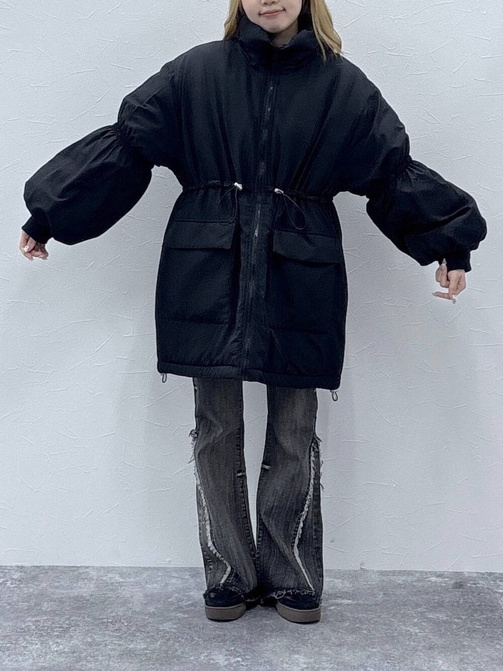 ブラック系のダウンジャケット/コート、レッド系のニット/セーター、ブラック系のデニムパンツを着用したレディースの秋コーディネートの3枚目の写真