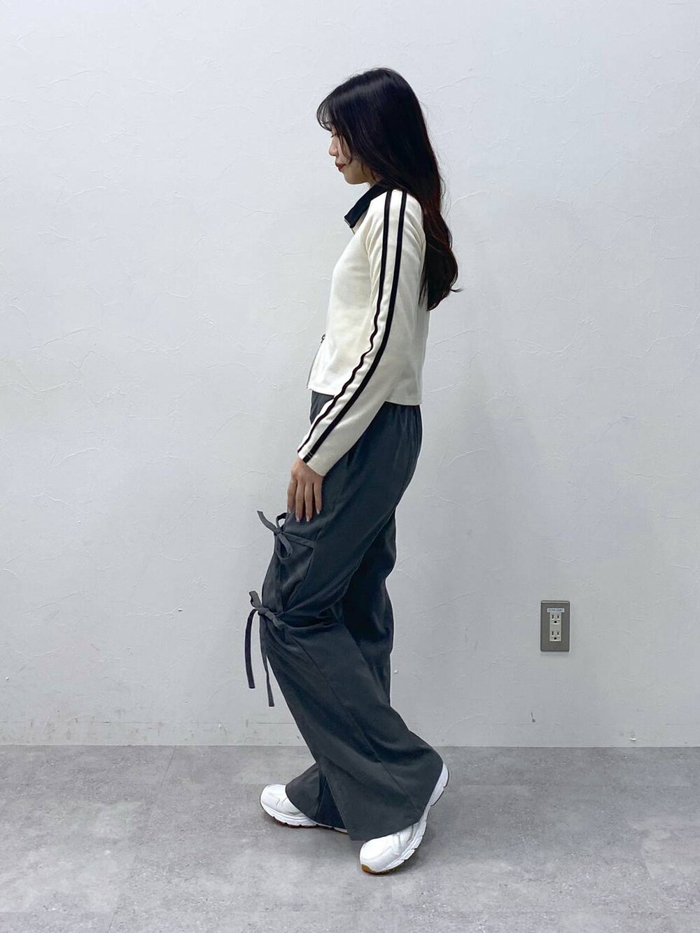 グレー系のスラックス、ベージュ系のTシャツ/カットソーを着用したレディースの冬コーディネートの3枚目の写真