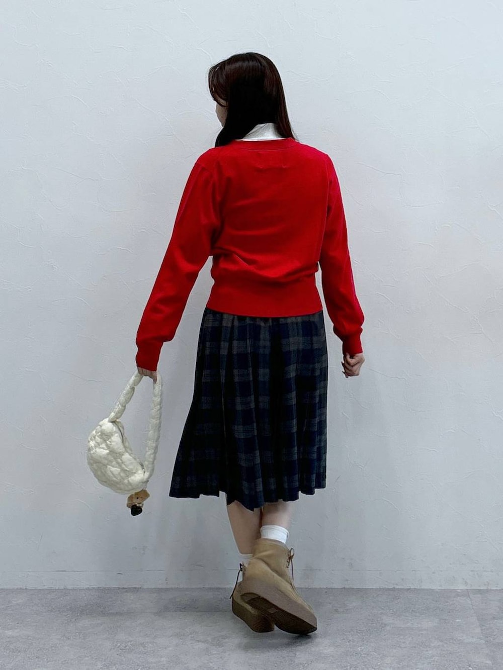 ホワイト系のショルダーバッグ、ホワイト系のニット/セーター、ベージュ系のブーツを着用したレディースの秋コーディネートの4枚目の写真