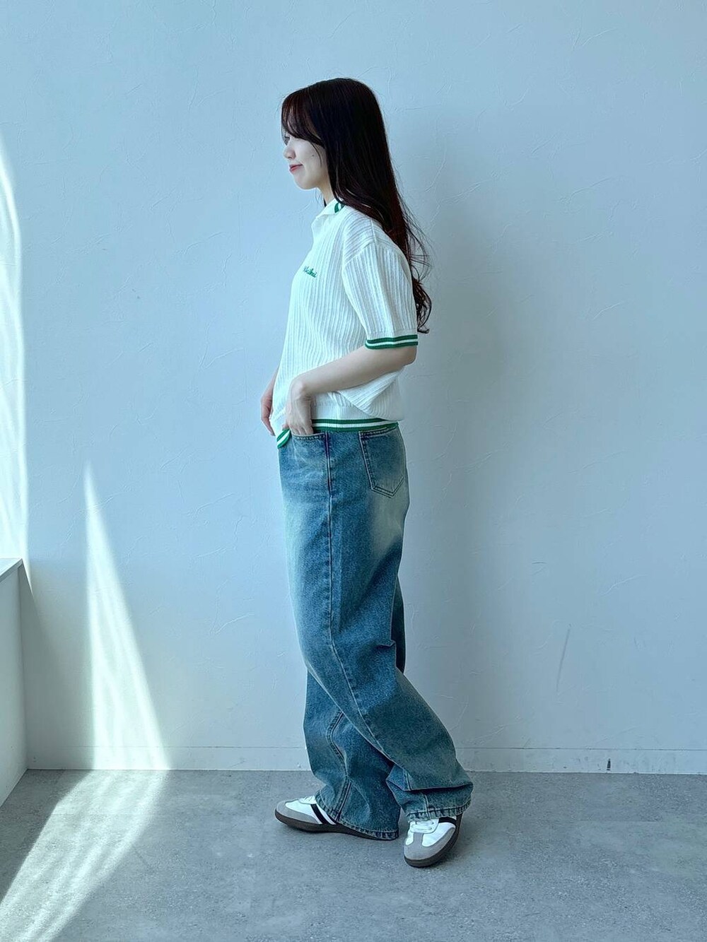 ベージュ系のニット/セーター、ブルー系のデニムパンツを着用したレディースの春コーディネートの3枚目の写真