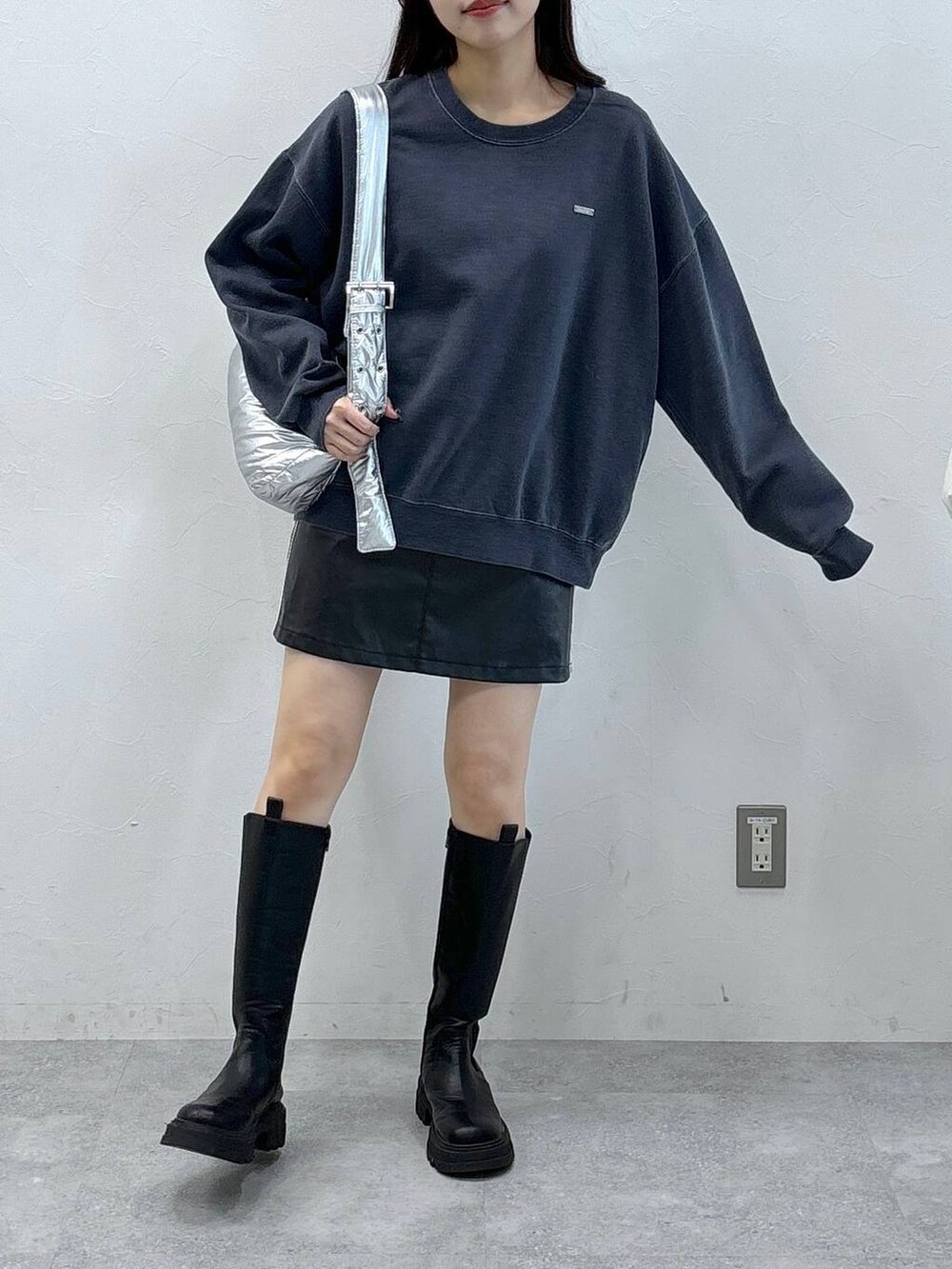 その他のショルダーバッグ、ブラック系のスカート、ブラック系のブーツを着用したレディースの冬コーディネートの2枚目の写真