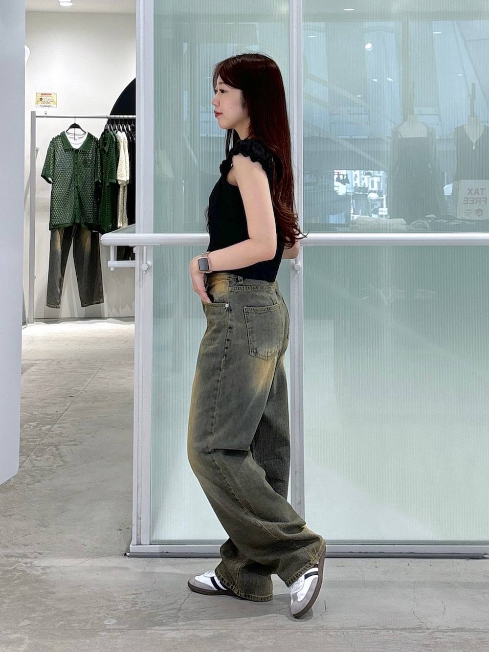 ブルー系のデニムパンツ、ブラック系のタンクトップを着用したレディースの夏コーディネートの2枚目の写真