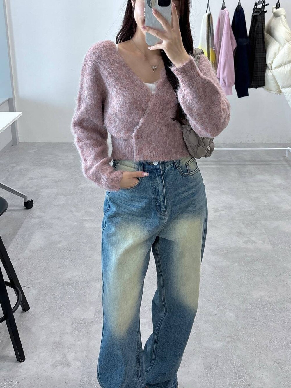 グレー系のショルダーバッグ、オレンジ系のカーディガン/ボレロ、ブルー系のデニムパンツを着用したレディースの秋コーディネートの5枚目の写真