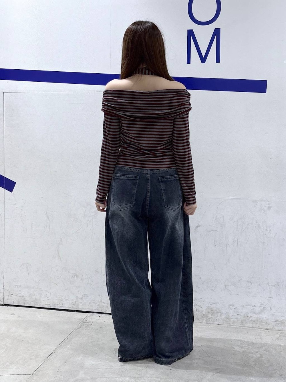 レッド系のTシャツ/カットソー、ブルー系のデニムパンツ、レッド系のサンダルを着用したレディースの秋コーディネートの4枚目の写真