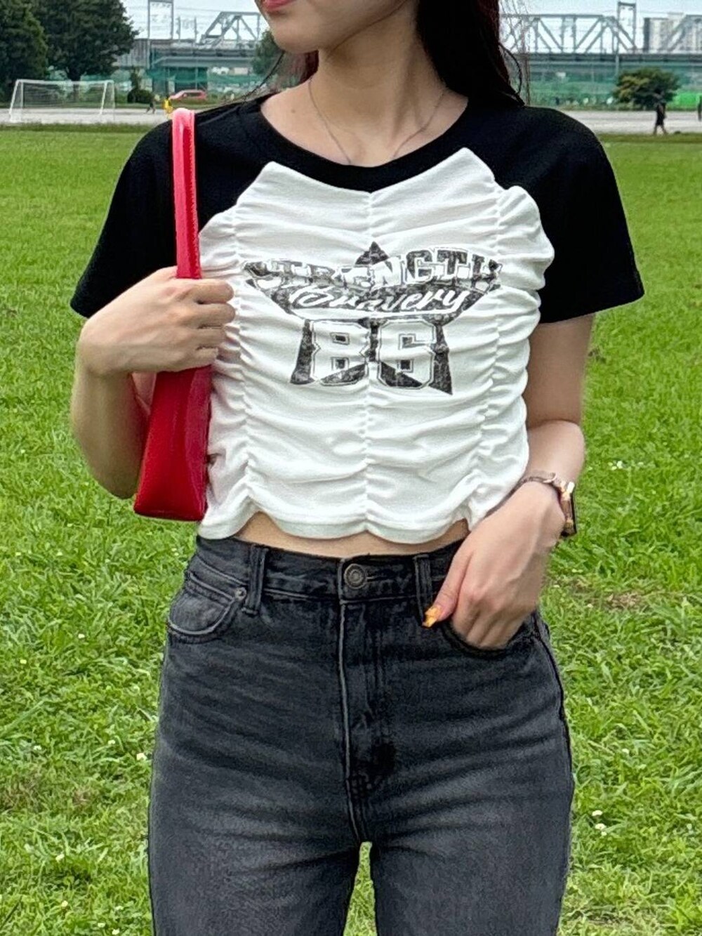 レッド系のハンドバッグ、ホワイト系のTシャツ/カットソーを着用したレディースの夏コーディネートの4枚目の写真