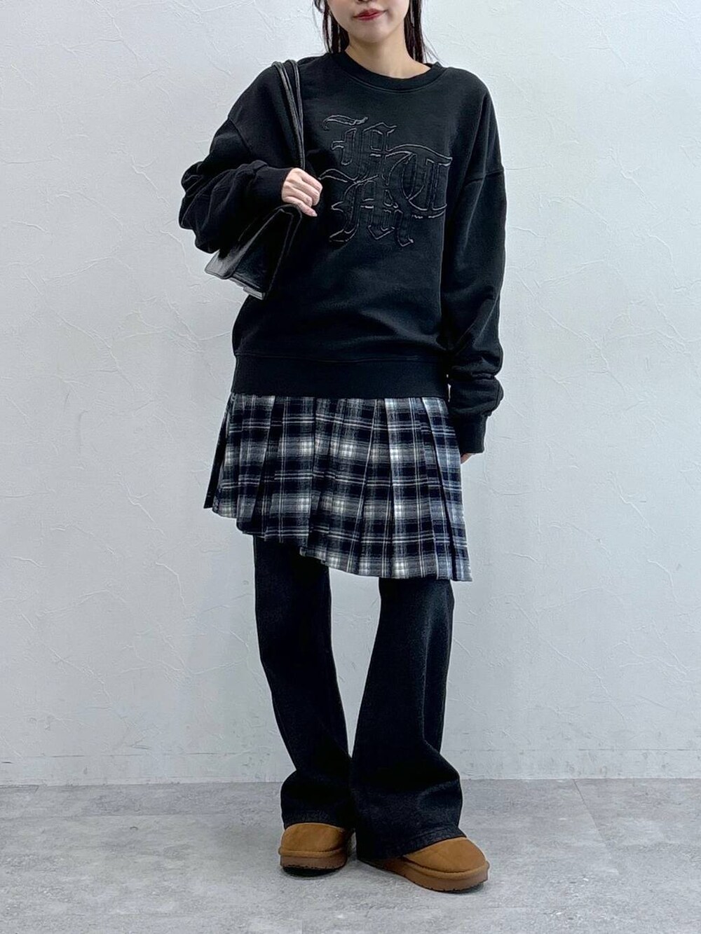 ブラック系のデニムパンツ、ブラック系のハンドバッグ、ブルー系のスカートを着用したレディースの冬コーディネートの3枚目の写真