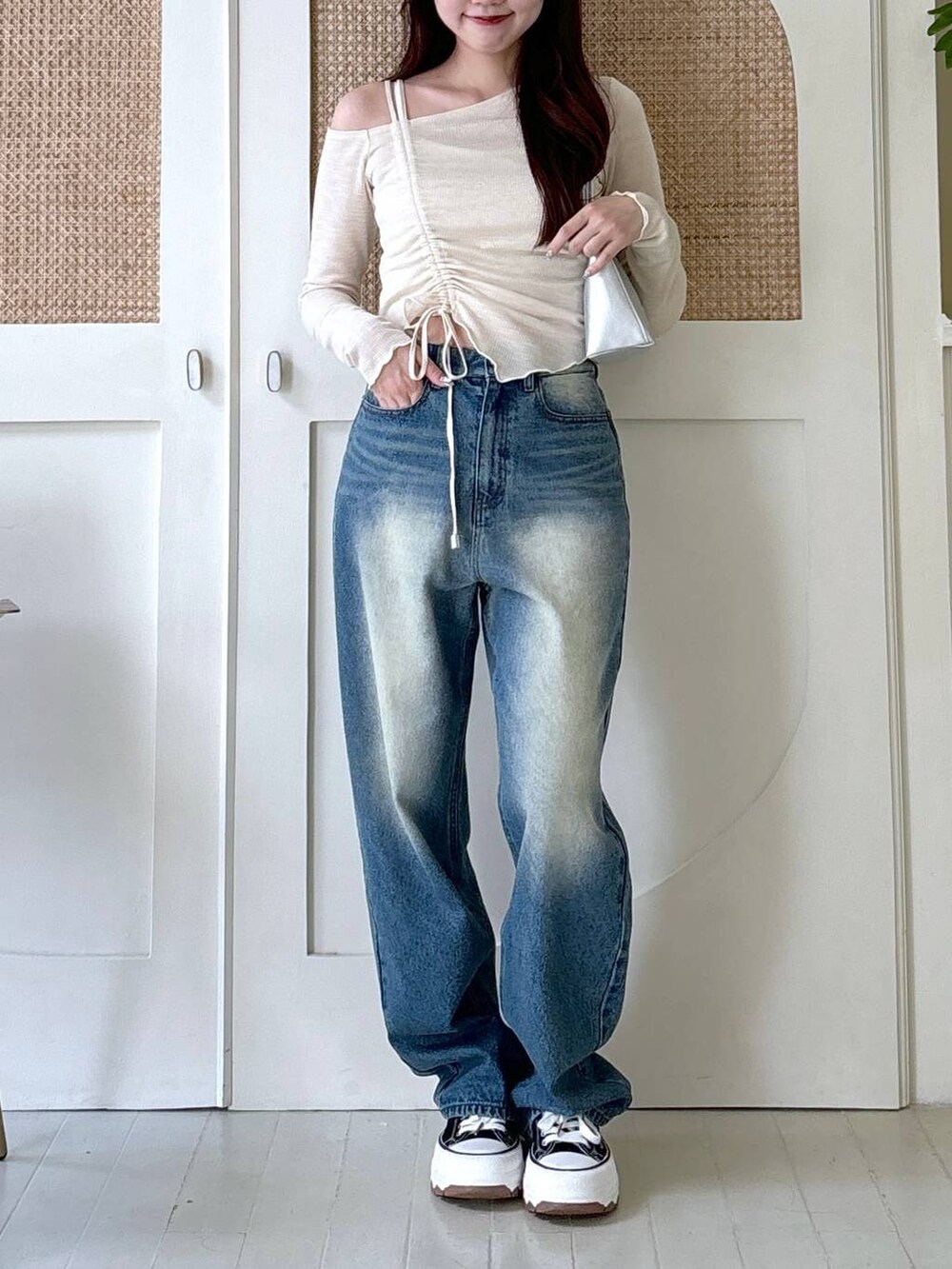 その他のハンドバッグ、ベージュ系のTシャツ/カットソー、ブルー系のデニムパンツを着用したレディースの秋コーディネートの2枚目の写真