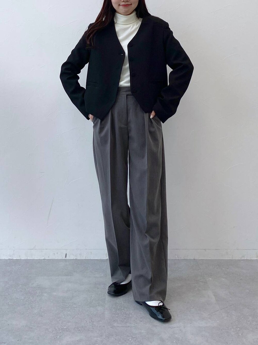 ブラック系のバレエシューズ、グレー系のスラックス、ブラック系のノーカラージャケットを着用したレディースの冬コーディネートの3枚目の写真