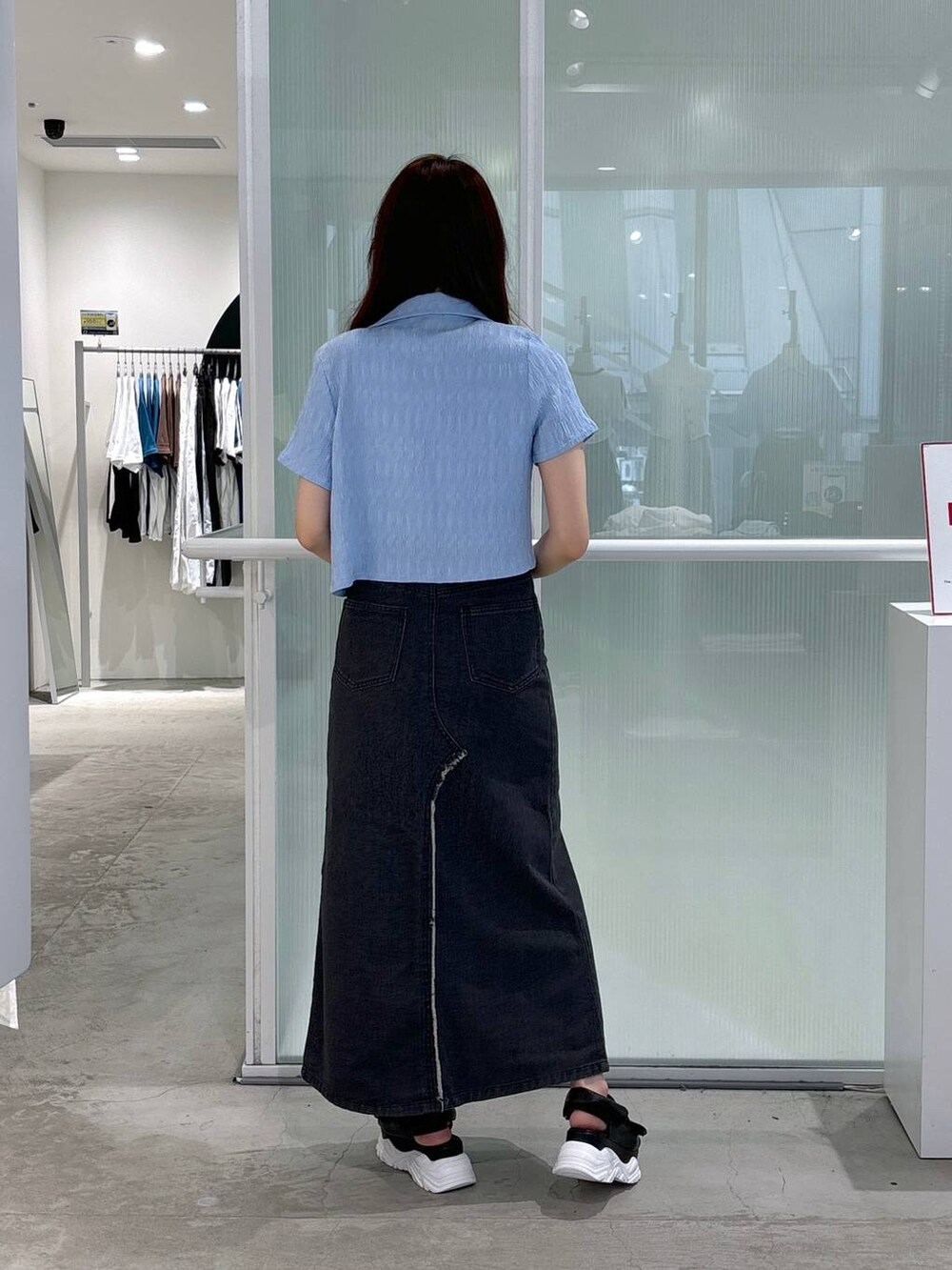 ブラック系のスカート、ブラック系のサンダル、ベージュ系のTシャツ/カットソーを着用したレディースの夏コーディネートの3枚目の写真