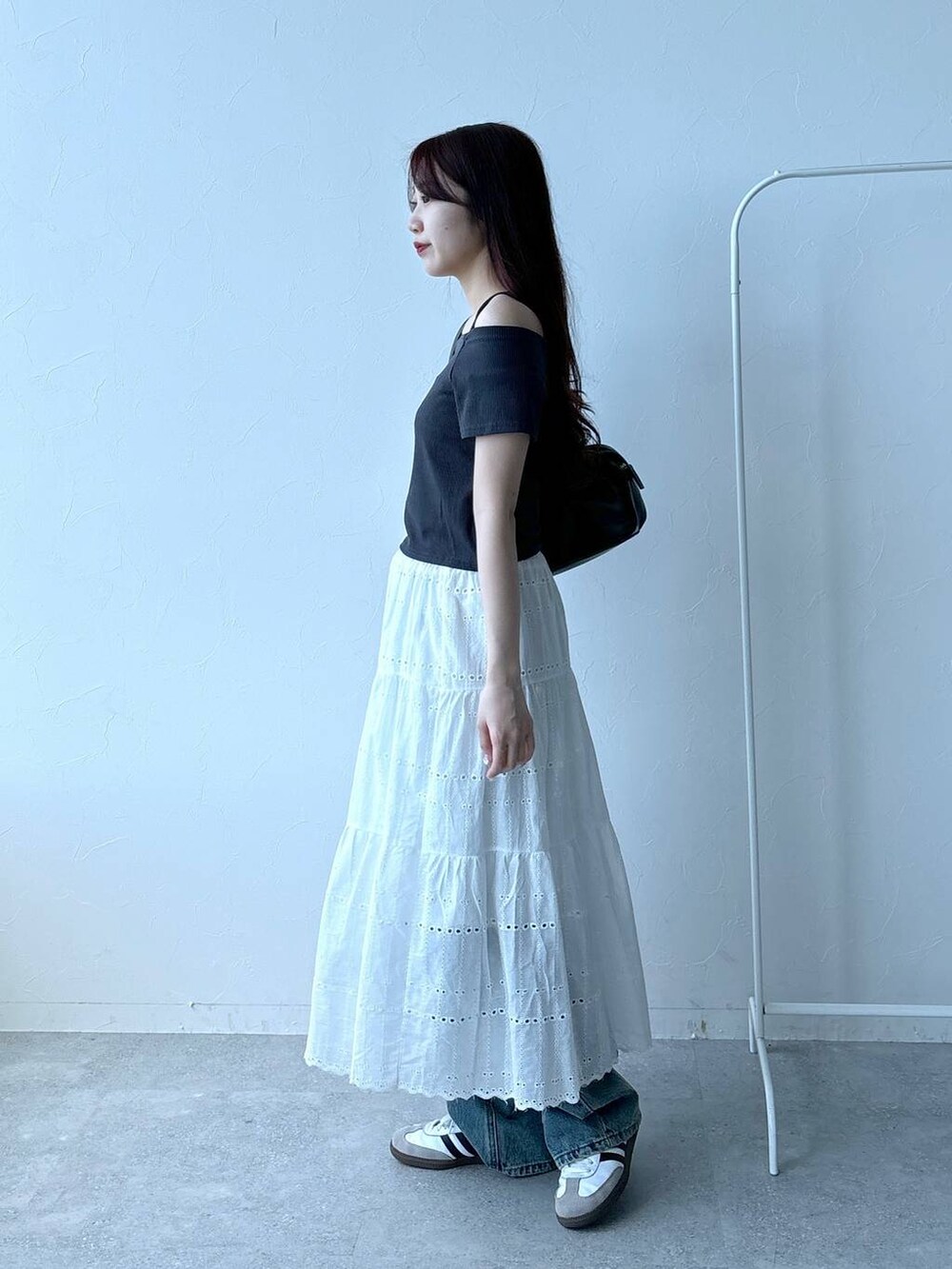 ブルー系のデニムパンツ、ベージュ系のスカート、グレー系のTシャツ/カットソーを着用したレディースの春コーディネートの3枚目の写真