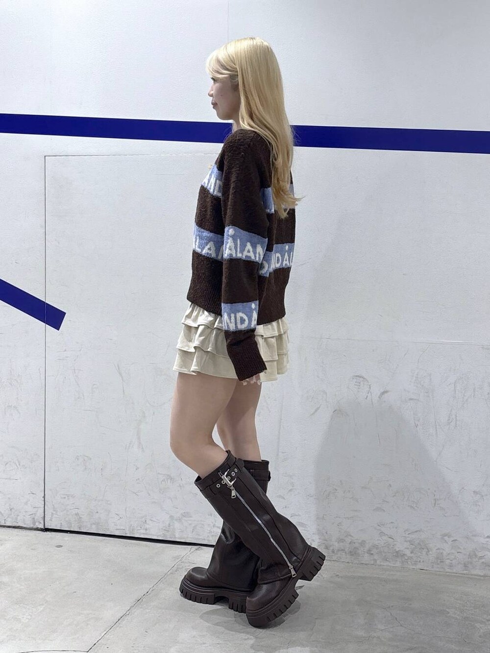 ブラウン系のニット/セーター、ブラウン系のブーツ、ベージュ系のスカートを着用したレディースの秋コーディネートの3枚目の写真