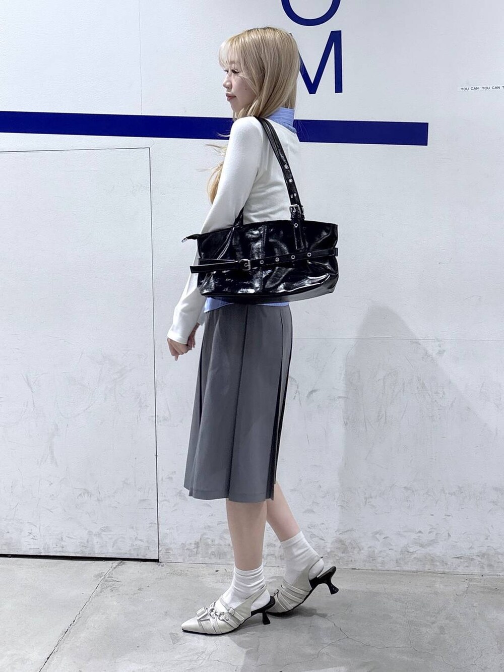 ホワイト系のパンプス、ブラック系のショルダーバッグ、ベージュ系のカーディガン/ボレロを着用したレディースの冬コーディネートの3枚目の写真