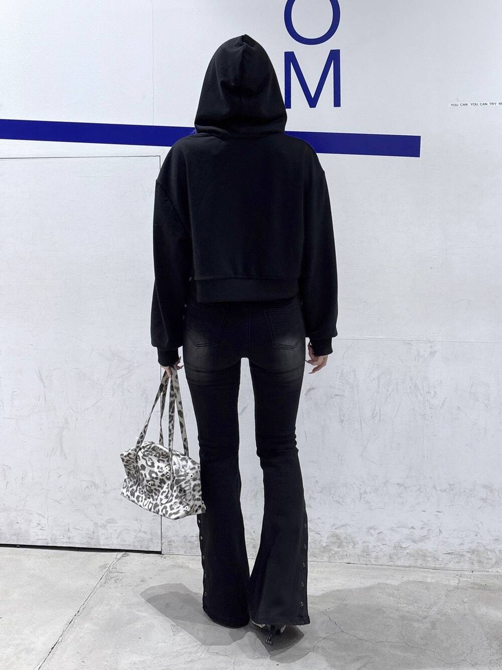 ホワイト系のパンプス、ブラック系のデニムパンツ、ホワイト系のショルダーバッグを着用したレディースの冬コーディネートの4枚目の写真