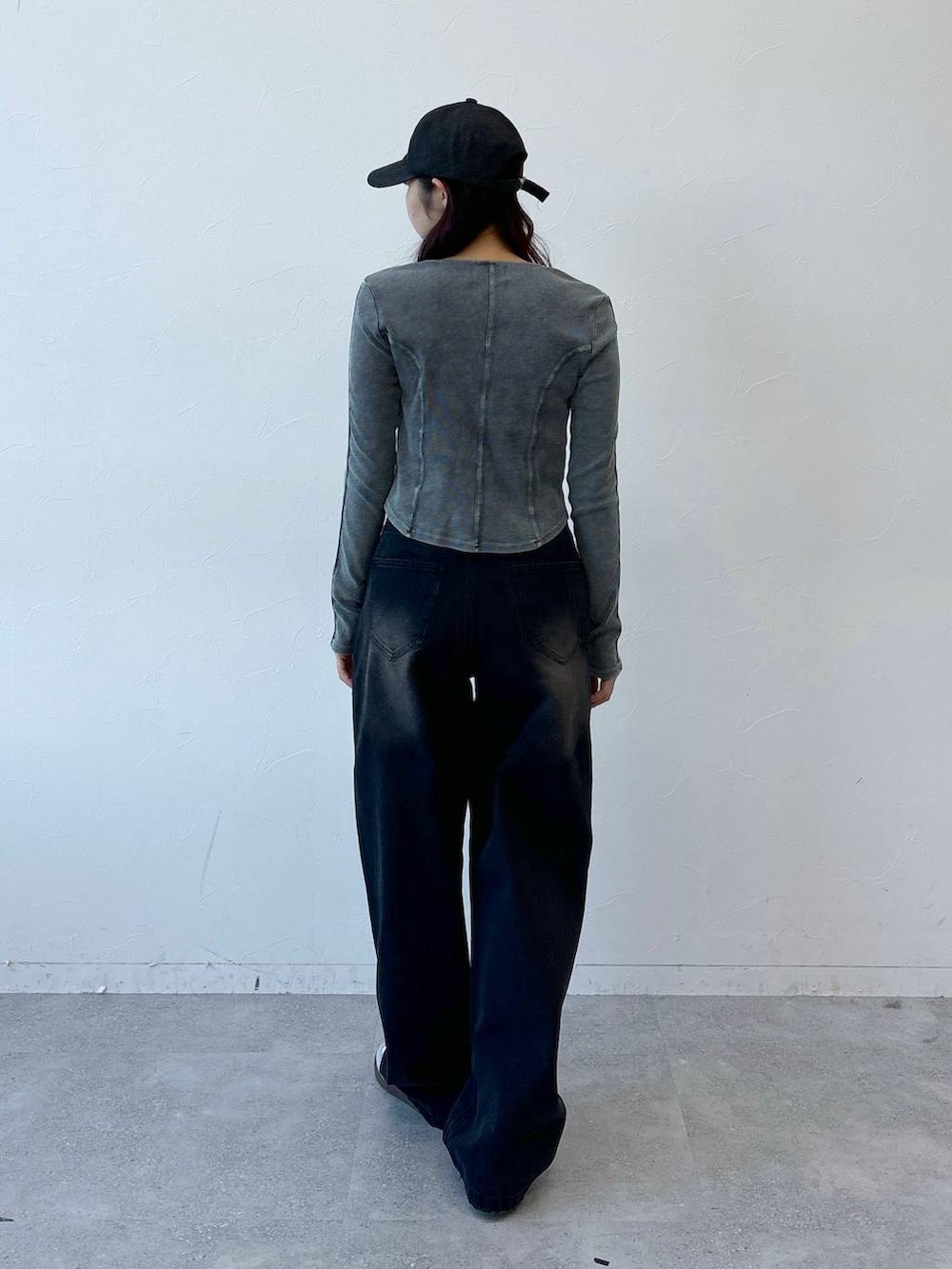 ブルー系のTシャツ/カットソー、ブラック系のデニムパンツ、ブラック系のキャップを着用したレディースの冬コーディネートの4枚目の写真