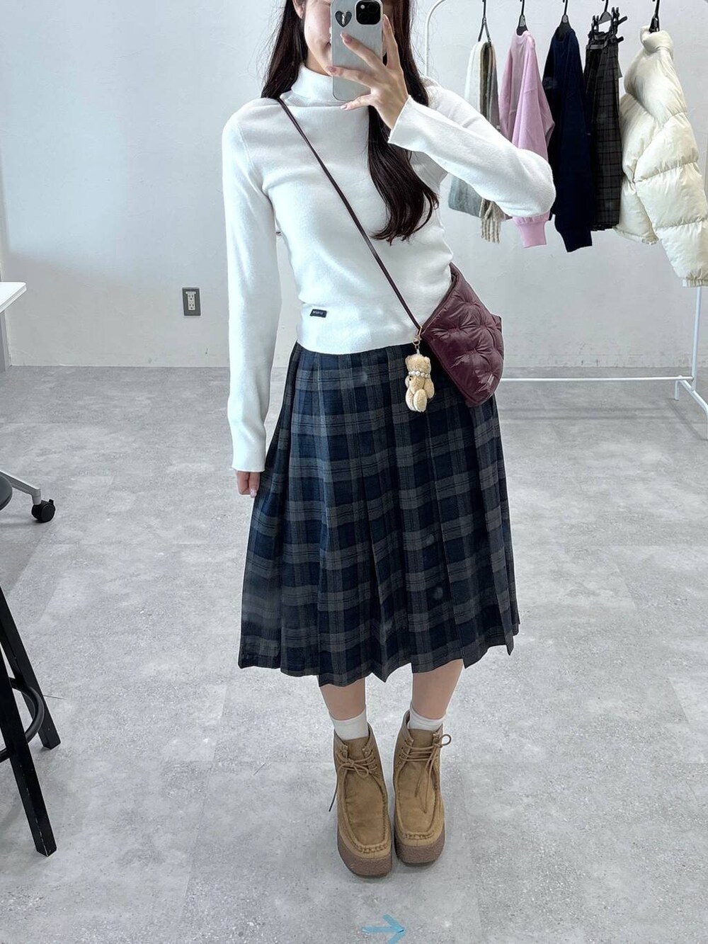 グレー系のスカート、ホワイト系のニット/セーター、ベージュ系のキーホルダーを着用したレディースの秋コーディネートの5枚目の写真