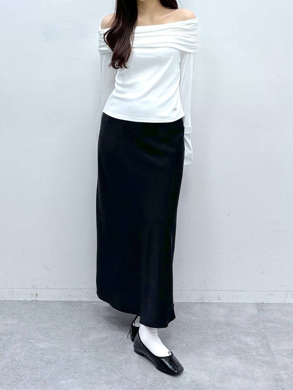 ブラック系のスカート、ホワイト系のTシャツ/カットソーを着用したレディースの春コーディネートの3枚目の写真