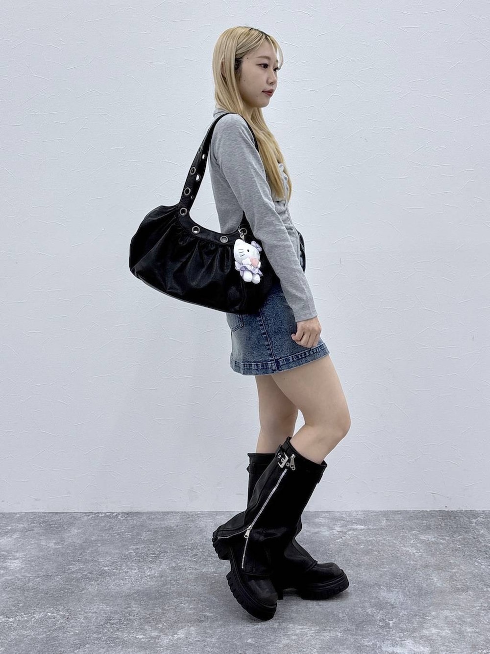 ブラック系のブーツ、グレー系のTシャツ/カットソー、ブラック系のショルダーバッグを着用したレディースの春コーディネートの3枚目の写真