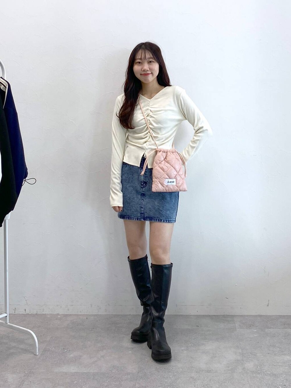 ブルー系のデニムスカート、ピンク系のショルダーバッグ、ベージュ系のTシャツ/カットソーを着用したレディースの冬コーディネートの3枚目の写真