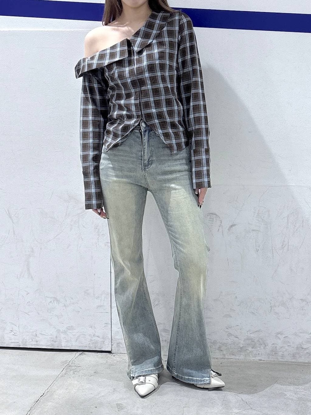 ブルー系のデニムパンツ、ホワイト系のパンプス、ブラウン系のシャツ/ブラウスを着用したレディースの春コーディネートの2枚目の写真