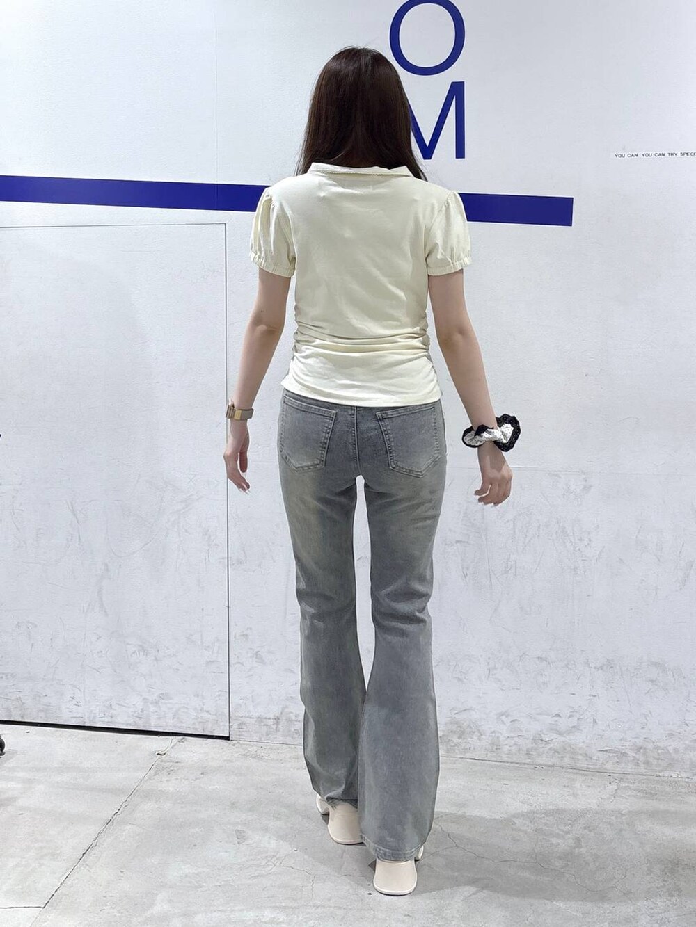 ホワイト系のサンダル、ベージュ系のTシャツ/カットソー、ブルー系のデニムパンツを着用したレディースの夏コーディネートの4枚目の写真