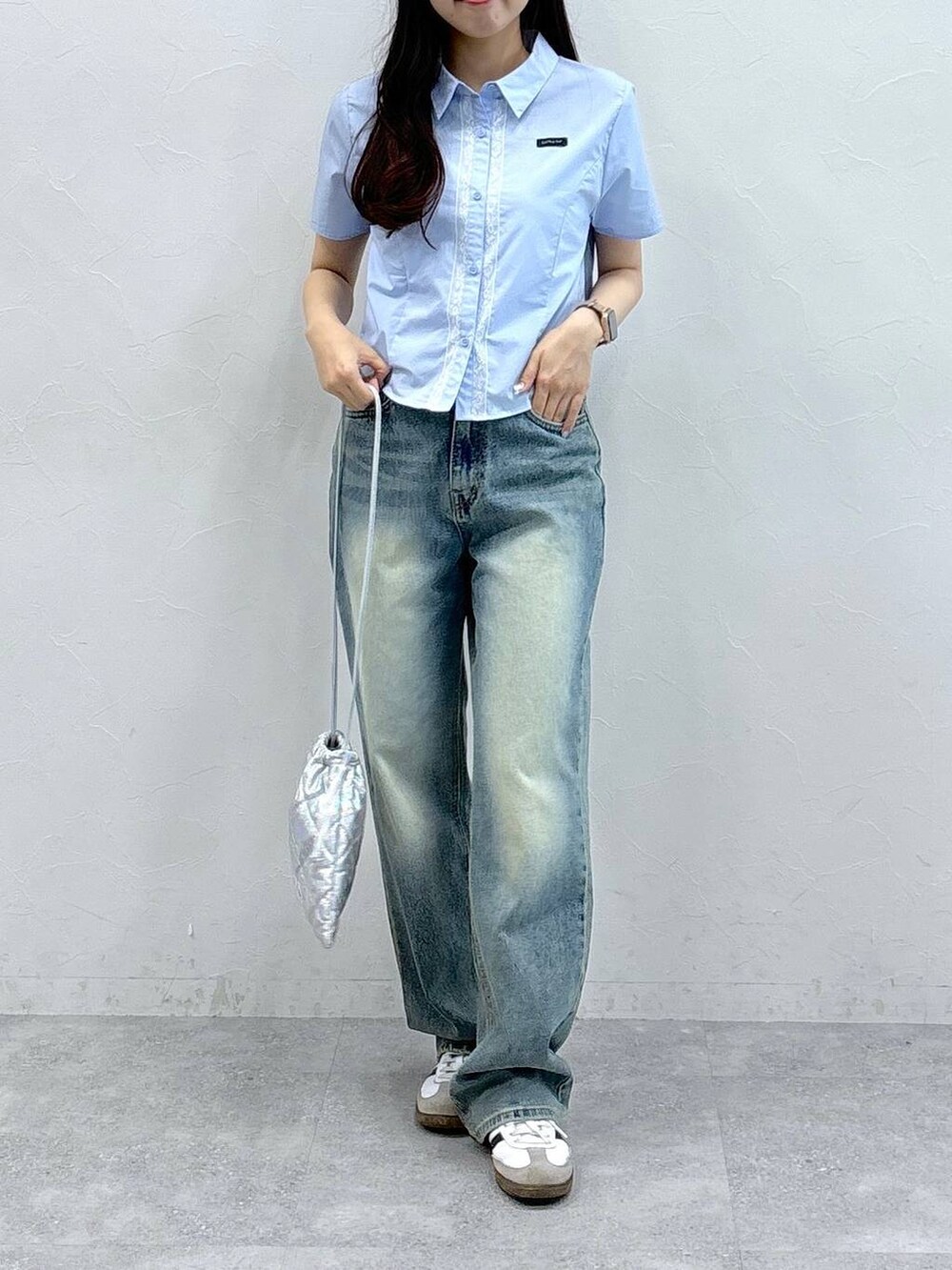 ブルー系のデニムパンツ、シルバー系のショルダーバッグ、ブルー系のシャツ/ブラウスを着用したレディースの夏コーディネートの2枚目の写真