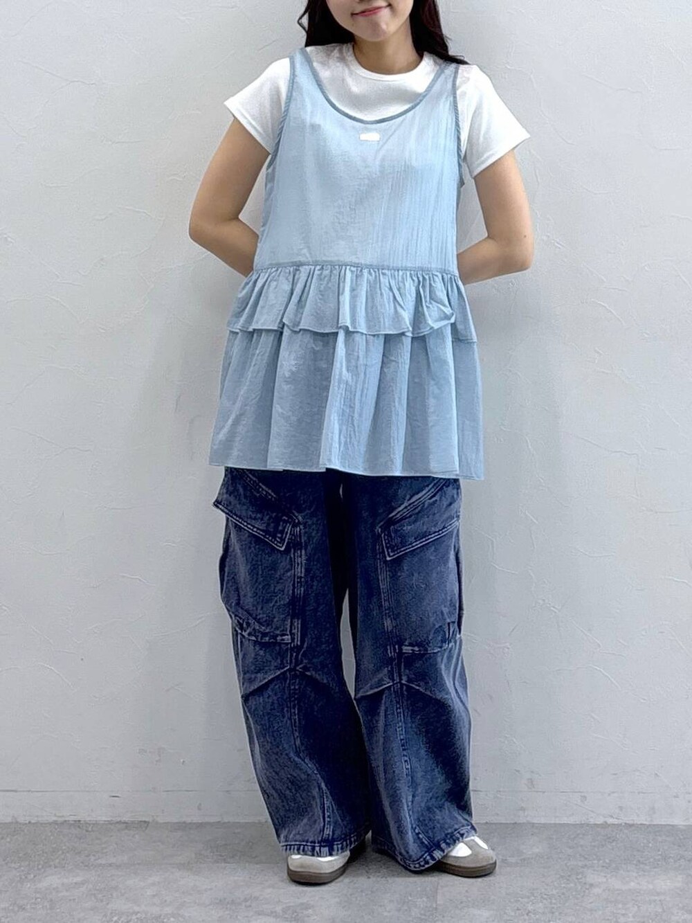 パープル系のカーゴパンツ、ブルー系のワンピース、ベージュ系のTシャツ/カットソーを着用したレディースの春コーディネートの2枚目の写真